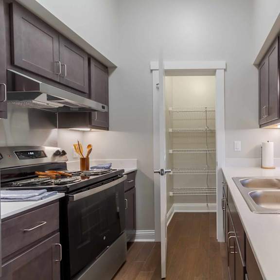 a kitchen with a stove, sink, and cabinets.