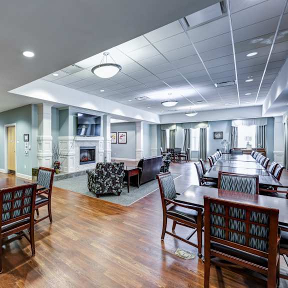 a large room with wooden floors and tables and chairs.