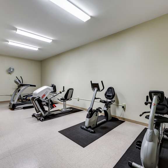 a well-lit gym with a variety of exercise equipment.