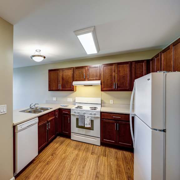 a kitchen with white appliances and wooden cabinets.