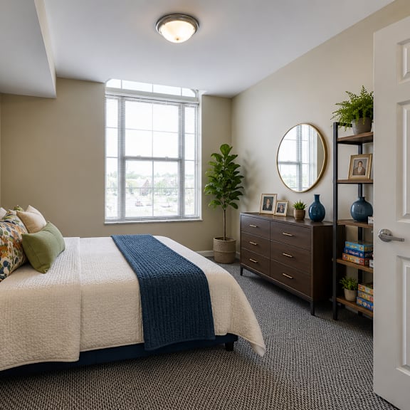a bedroom with a bed, nightstand, and a window.