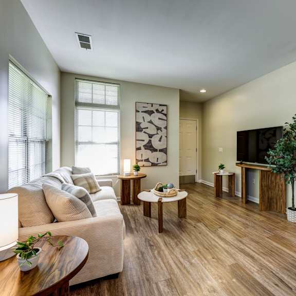 a living room with a white couch and wooden floors.