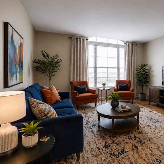 a living room with a blue couch, a coffee table, and a television.