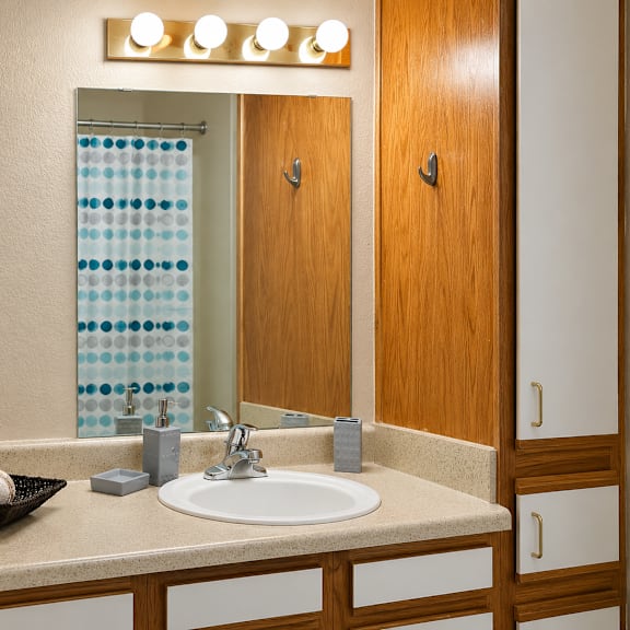 a bathroom with a sink, mirror, and a tray of bath bombs.