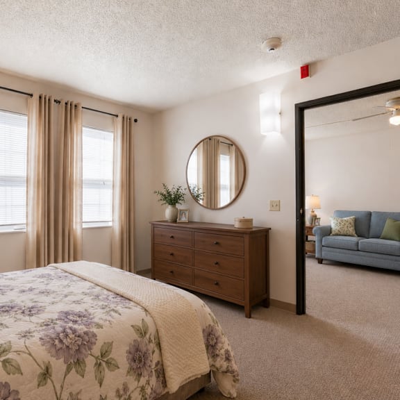 a bedroom with a large bed, a dresser, a mirror, and a couch.