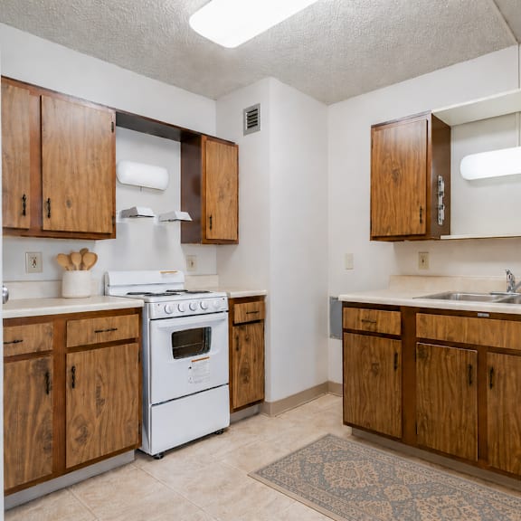 a kitchen with wooden cabinets and a white stove.