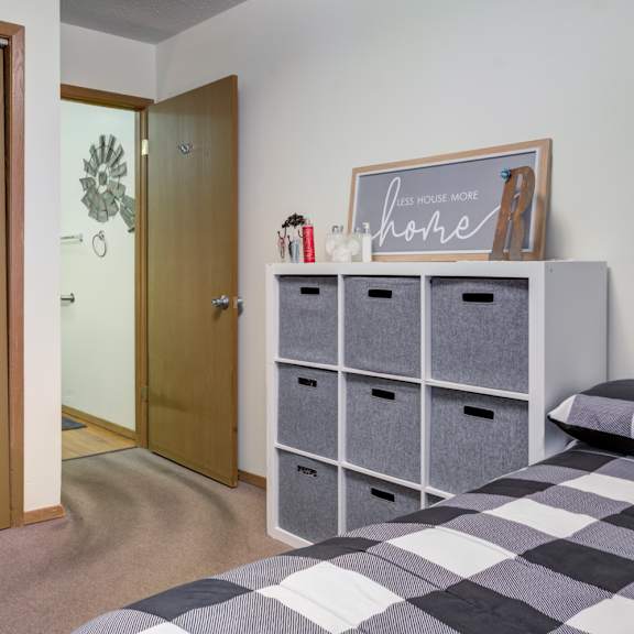 a room with a bed, a dresser, and a door.