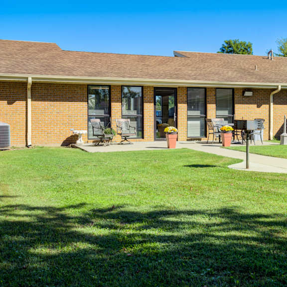 a house with a brown roof and a green lawn in front.