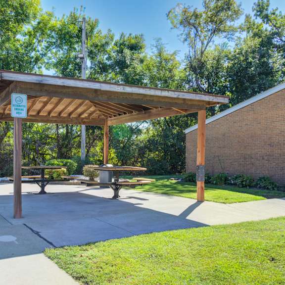 a covered picnic area with a sign on the roof.