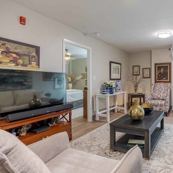 a living room with a white couch, a coffee table, and a flat screen tv.