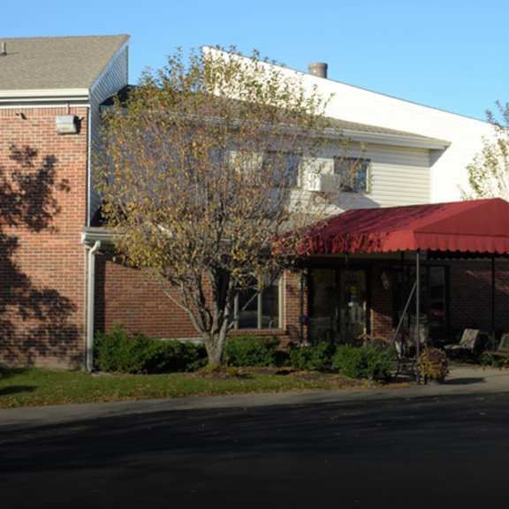 a red canopy is on a building in front of a brick building.