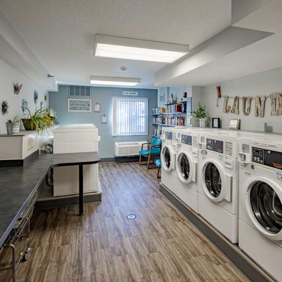 a laundry room with washing machines and a counter.