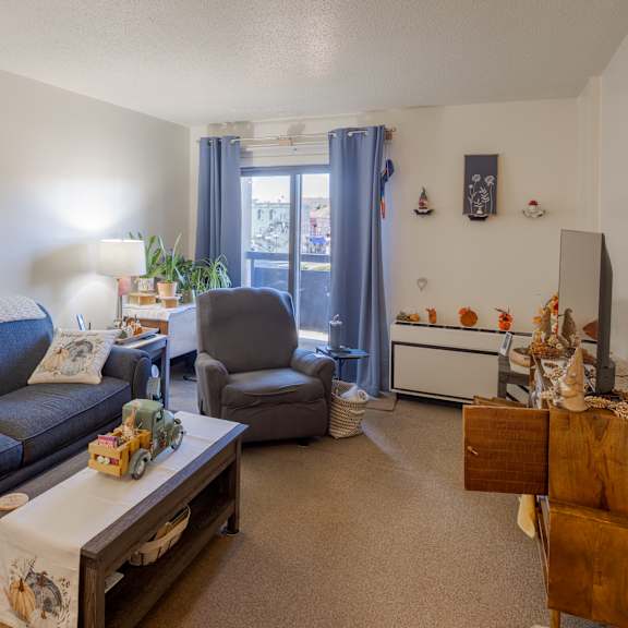 a living room with a blue couch and a painting on the wall.