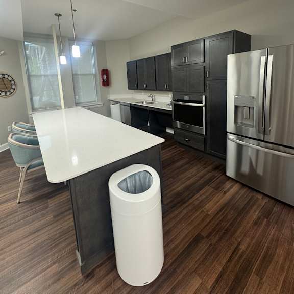 a white kitchen with a wooden floor and a white counter.