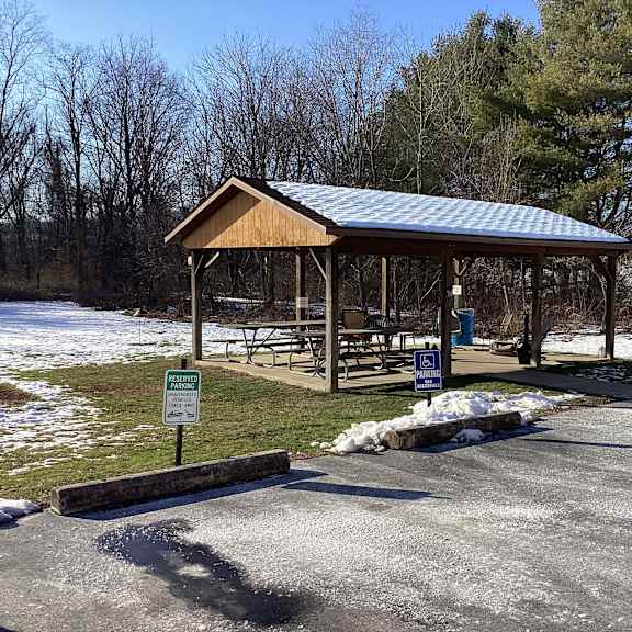 a covered picnic area with a sign in front of it.