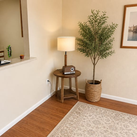 a small tree in a basket sits on a table next to a lamp in a kitchen.