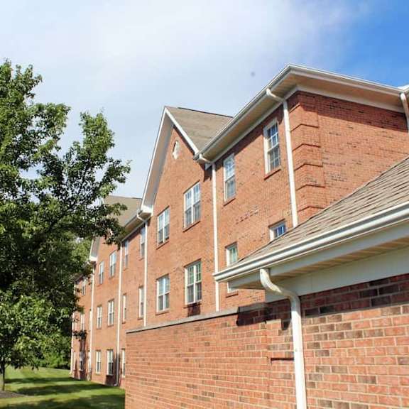 a red brick building with a tree in front of it.