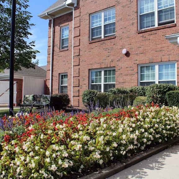 a red brick building with a flower bed in front.