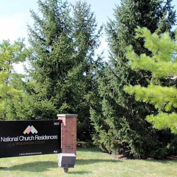 a sign for national church residences is in front of some trees.