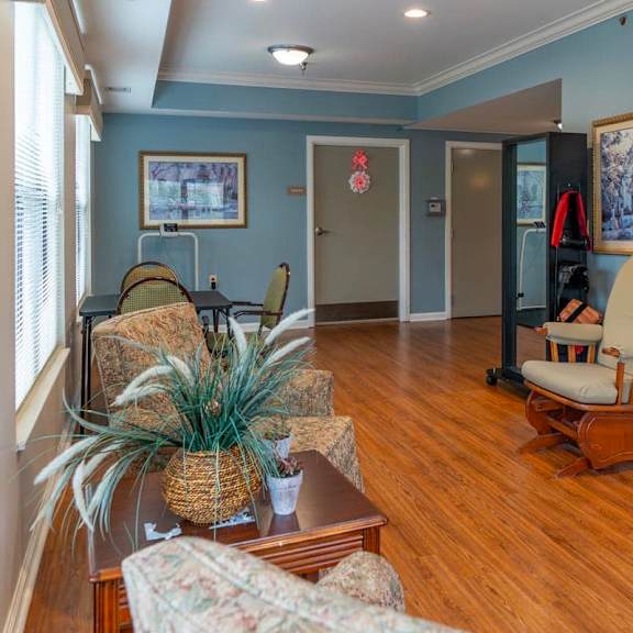 a living room with a wooden floor and a chair.