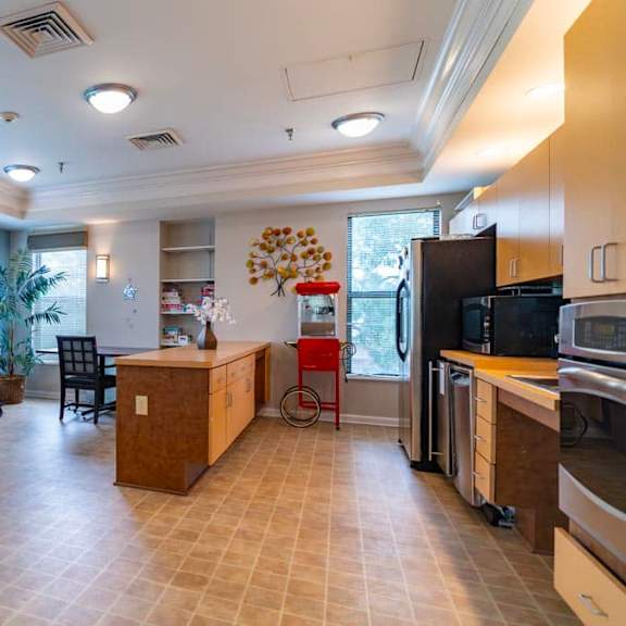 a kitchen with a dining table and chairs is visible.
