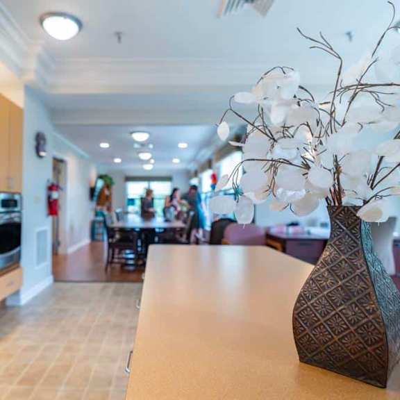 a modern kitchen with a large island and a vase of white flowers on the counter.