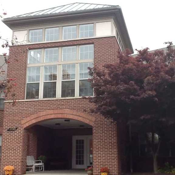 a house with a red brick archway and a white door.
