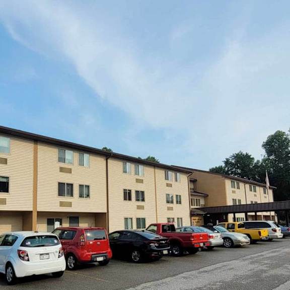 a parking lot in front of a building with cars parked.