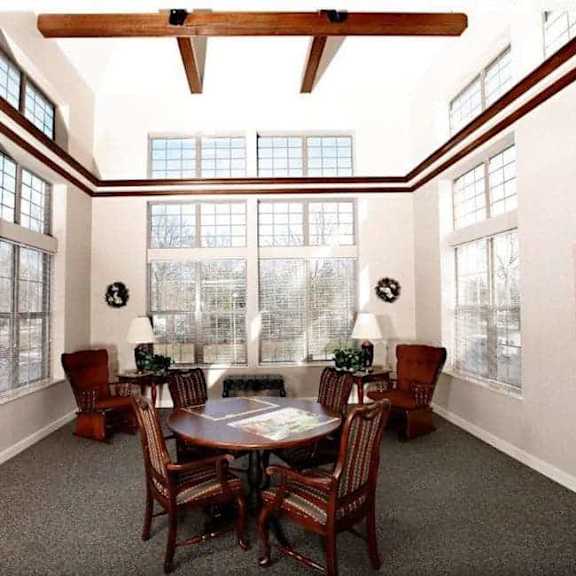 a dining room with a table surrounded by chairs and a ceiling fan.
