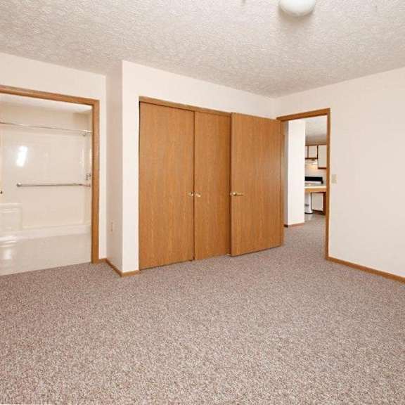 a room with a carpeted floor and a wall-mounted light fixture.
