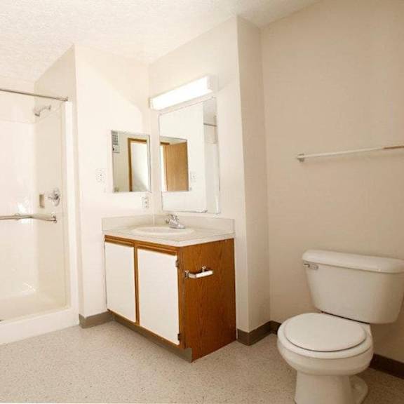 a white toilet sits next to a sink in a bathroom.