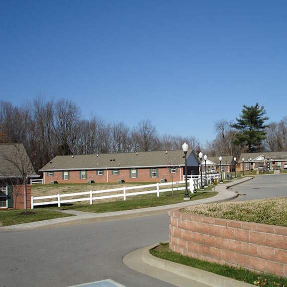a small town with a white fence and a brick wall.