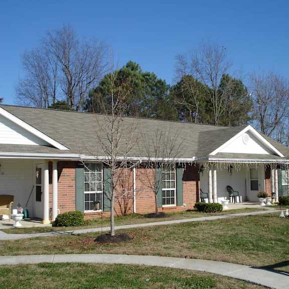 a house with a white porch and green shutters.
