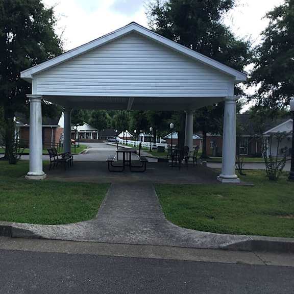 a white covered walkway leads to a building.
