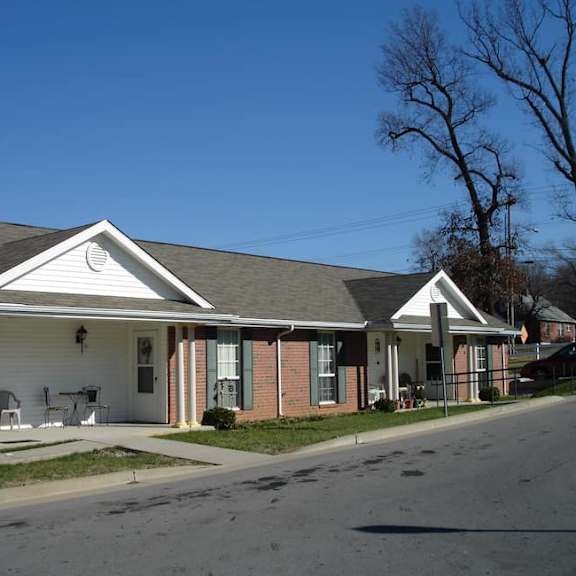 a white house with a grey roof and a porch.
