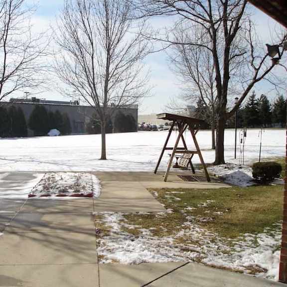 a playground with a swing set and a snow-covered ground.