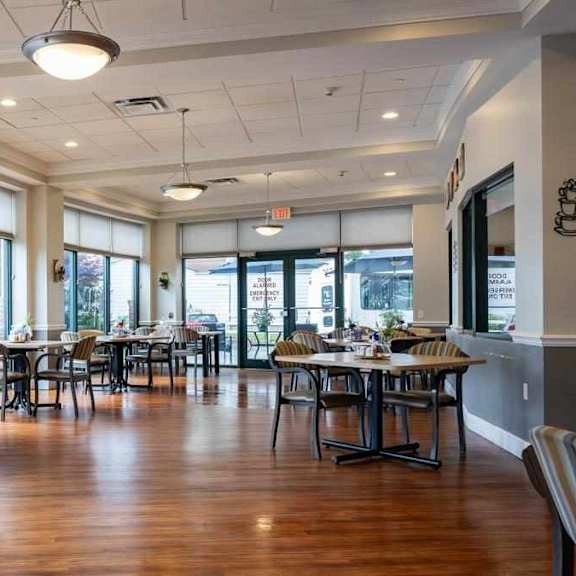 a large room with tables and chairs is empty.