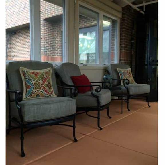 three chairs with cushions are placed on a patio.