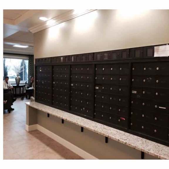 a row of black mailboxes are lined up on a wall.