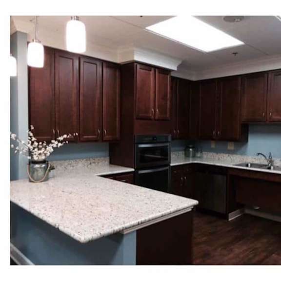 a kitchen with brown cabinets and a granite countertop.