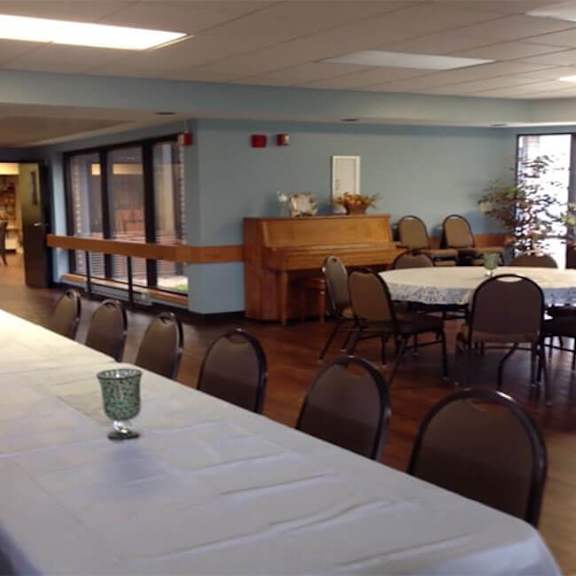 a room with tables and chairs and a piano.