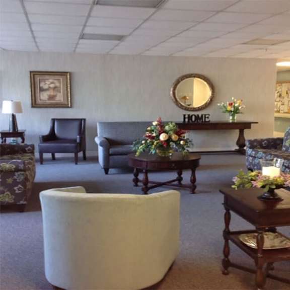 a living room with a white chair and a sign that says "home".