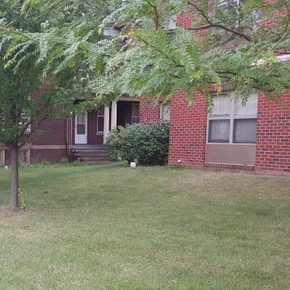 a red brick house with a white door and a mailbox.