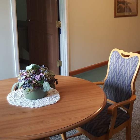 a table with a vase of flowers on it and two chairs.