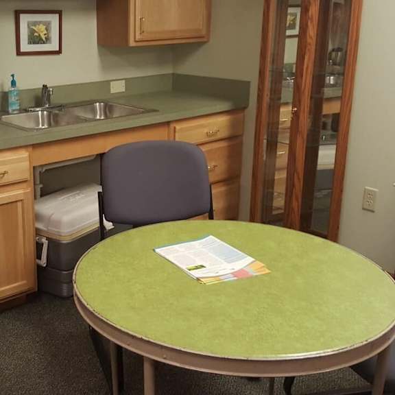 a small table with a green top is in the middle of a kitchen.