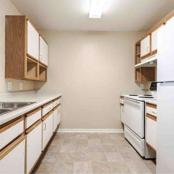 a kitchen with white appliances and wooden cabinets.