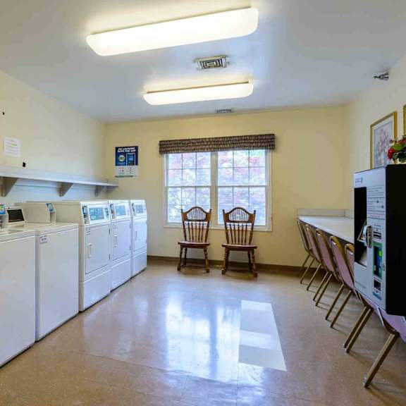 a laundry room with washers and dryers and a small table and chairs.