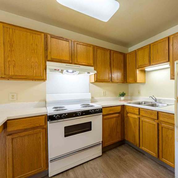 a kitchen with wooden cabinets and a white refrigerator.