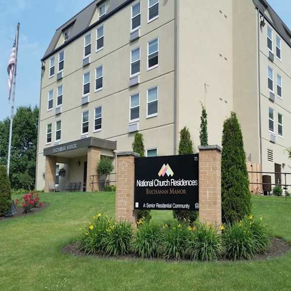the image shows a building with a sign in front that reads "national church residences bugnaran manor & senior residential community".