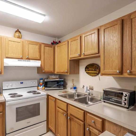 a kitchen with wooden cabinets and a white stove top oven.